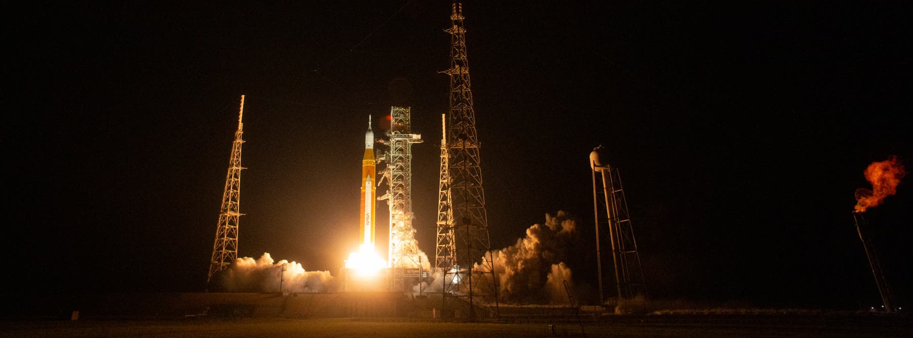 Artemis I lifting off at night from Kennedy Space Center.